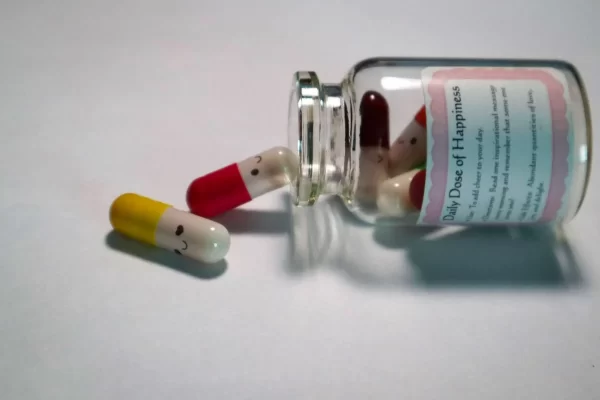 A bottle of pills with happy faces on them, reading "daily dose of happiness"